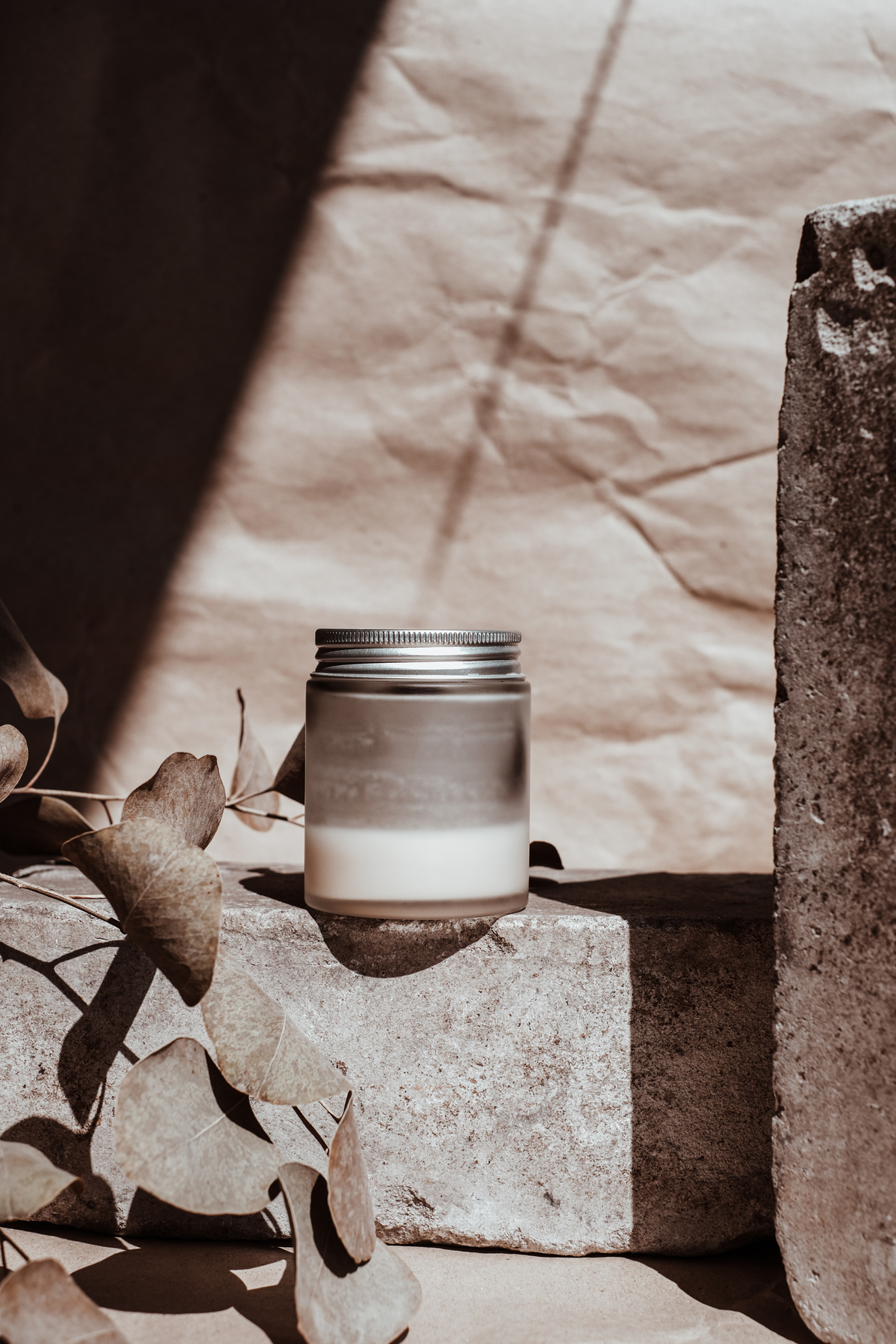 Glass Container of Cosmetic Product on Rock with Leaves